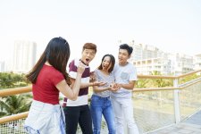 pretty-young-woman-surprising-her-friends-with-focus-when-they-are-standing-bridge.jpg